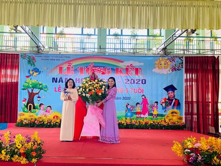 Hiệu trưởng nhà trường nhận hoa Từ Bà Vương Thị Thanh Lan Phó bí thư Đảng ủy Thị Trấn Dầu Tiếng.